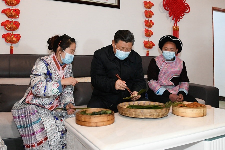 2021年2月3日下午，習(xí)近平在貴州畢節(jié)市黔西縣新仁苗族鄉(xiāng)化屋村苗族村民趙玉學(xué)家，同一家人邊聊家常邊制作當(dāng)?shù)貍鹘y(tǒng)節(jié)日食品黃粑。新華社記者 李學(xué)仁 攝
